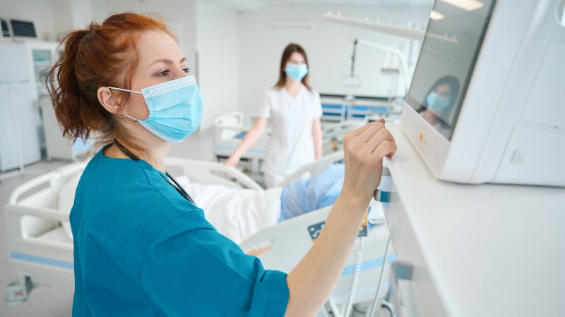 Pflegekraft am Monitor im Patientenzimmer