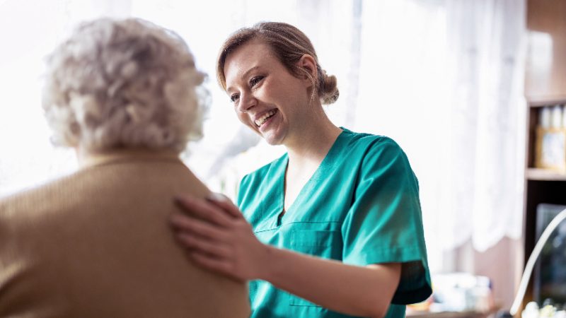 Pflegekraft im Gespräch mit Bewohnerin